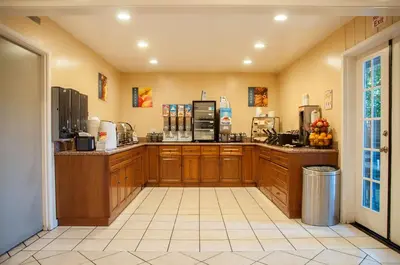 a large kitchen with wooden cabinets and a counter at Best Western Village Inn in Fresno