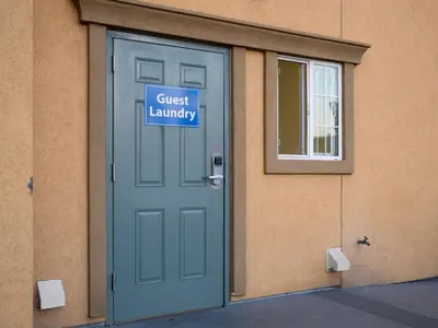 a door with a guest laundry sign in front of a building at Rodeo Lodge in Clovis