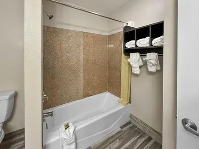 a bathroom with a bath tub and a toilet at Rodeo Lodge in Clovis