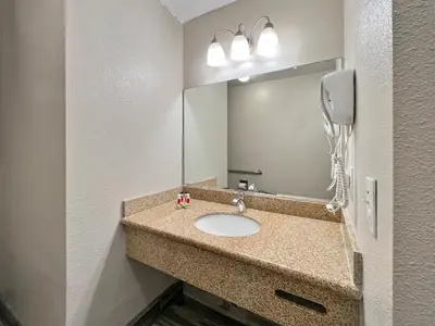 a bathroom with a sink and a mirror at Rodeo Lodge in Clovis