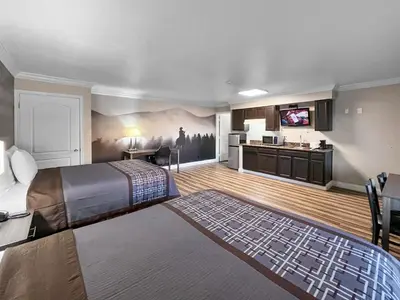 a large hotel room with a bed and a kitchen at Rodeo Lodge in Clovis