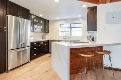 a kitchen with a stainless steel refrigerator and wooden cabinets at Snowflower 12 in Mammoth Lakes