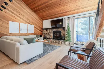 a living room with a couch and a fireplace at Snowflower 12 in Mammoth Lakes