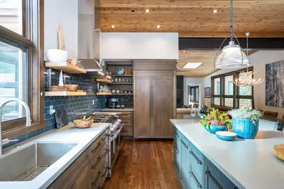 a large kitchen with blue cabinets and wooden ceilings at West Shore - West Shore Hideaway in Tahoma