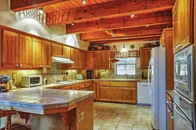 a large kitchen with wooden cabinets and a counter top at Hot Tub, Deck and Trail Access Shaver Lake Cabin in Shaver Lake