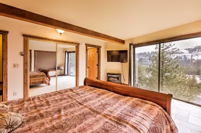 a bedroom with a bed and a large window at Cozy Lake-View Hideaway! Pet-Friendly Truckee Home in Truckee