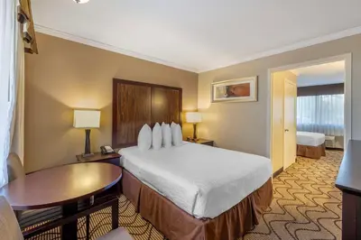 a hotel room with a bed and a table at Best Western Plus Orchid Hotel & Suites in Roseville