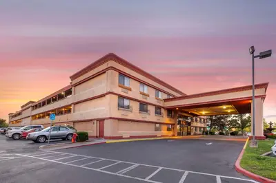 a building with cars parked in a parking lot at Best Western Plus Orchid Hotel & Suites in Roseville