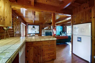 a kitchen with wooden cabinets and a white refrigerator at Boutique and Artsy Log Cabin in North Lake Tahoe! in Kings Beach