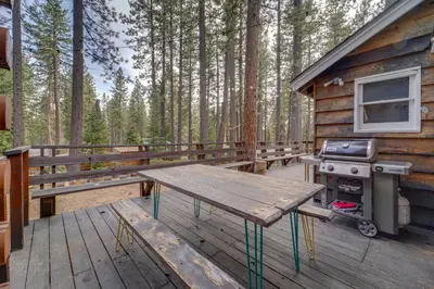 a wooden deck with a picnic table and a grill at Boutique and Artsy Log Cabin in North Lake Tahoe! in Kings Beach