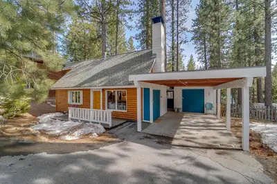 a small house with a garage in the woods at Boutique and Artsy Log Cabin in North Lake Tahoe! in Kings Beach