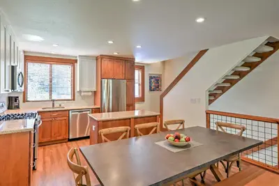 a kitchen with a table with a bowl of fruit on it at Modern Condo with Balcony - Walk to Northstar Lifts! in Truckee