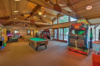 a room with a pool table and a arcade game at Modern Condo with Balcony - Walk to Northstar Lifts! in Truckee