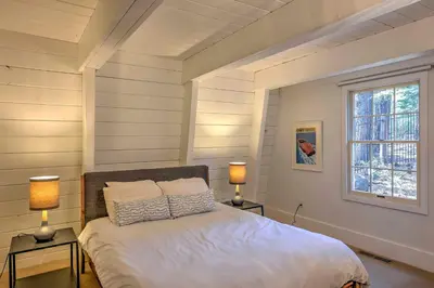 a bedroom with a bed with two lamps and a window at 10 Mi to Skiing Tahoe City A-Frame Home in Tahoe City