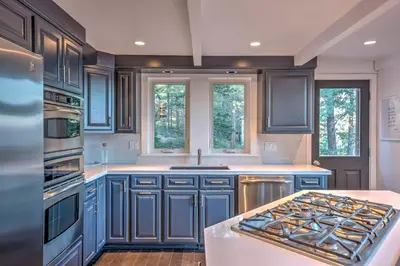 a kitchen with blue cabinets and a stove top oven at 10 Mi to Skiing Tahoe City A-Frame Home in Tahoe City