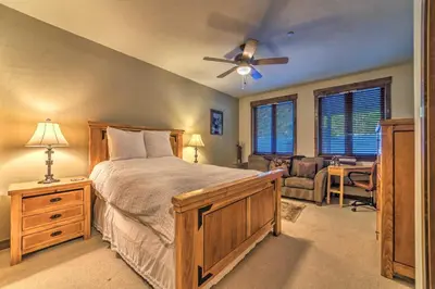 a bedroom with a bed with a ceiling fan and a desk at Central Mammoth Lakes Townhome about 1 Mi to Slopes in Mammoth Lakes