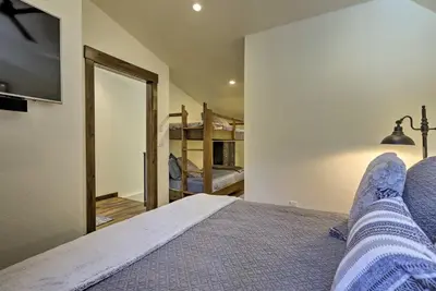a bedroom with a bed with a tv and a mirror at Walk to Ski Shuttle Truckee Condo with Hot Tub in Truckee