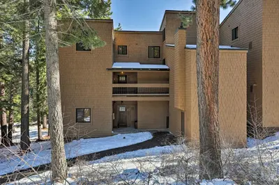 a brick building with trees in the snow at Walk to Ski Shuttle Truckee Condo with Hot Tub in Truckee