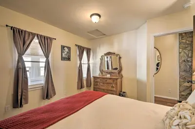 a bedroom with a bed and a mirror and a window at Historic Mariposa Stagecoach Stop with Gas Fire Pit! in Mariposa