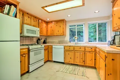 a kitchen with wooden cabinets and white appliances at Hot Tub Access, Near Skiing Tahoe Donner Cabin in Truckee