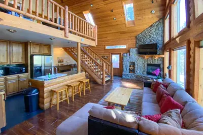 a living room with a large couch in a cabin at Hot Tub, Indoor Pool! Home 8 Mi to Heavenly Skiing in South Lake Tahoe