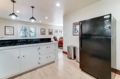 a kitchen with a black refrigerator and white cabinets at Less Than 15 Mi to 6 Ski Resorts Tahoe Donner Escape! in Truckee