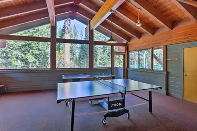two ping pong tables in a room with windows at Rustic Truckee Lodge with Rec Room - Near Northstar! in Truckee
