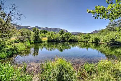 a river with trees and mountains in the background at Renovated Mammoth Lakes Retreat with Private Balcony in Mammoth Lakes
