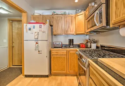 a kitchen with a white refrigerator and wooden cabinets at Cabin Less Than 2 Mi to Tahoe Donner Downhill Ski Resort in Truckee