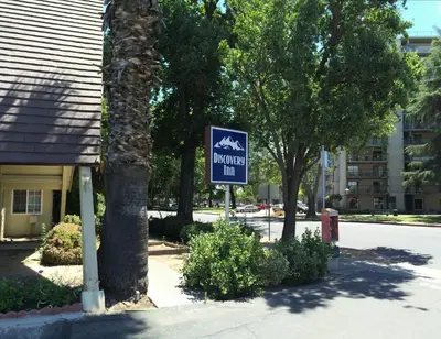 a sign for a mountain inn in front of a building at Discovery Inn in Modesto