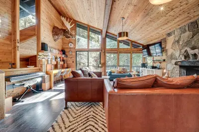 a living room with a large couch and a fireplace at Free Ski Shuttle! Spacious Northstar Resort Cabin in Truckee
