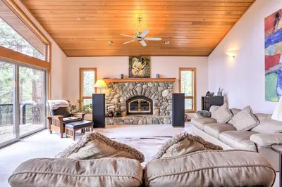 a living room with two couches and a stone fireplace at Mtn and Lake Views Incline Village Ski Chalet in Incline Village