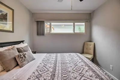 a bedroom with a bed and a window and a chair at Ski, Hike and Unwind Cozy Carson City Duplex! in Carson City