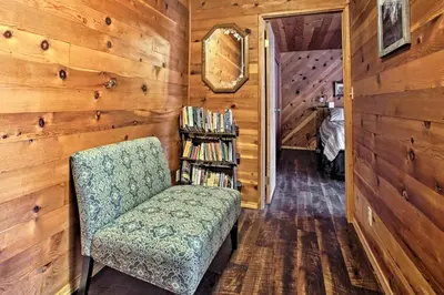 a room with a chair and a book shelf at Cozy Home with Patio Near Yosemite National Park! in Mariposa