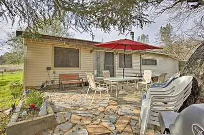 a patio with a table and chairs and an umbrella at Cozy Home with Patio Near Yosemite National Park! in Mariposa