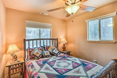 a bedroom with a bed and a ceiling fan at 4 Mi to Pine Lake Hathaway Pines Cabin with Deck in Hathaway Pines