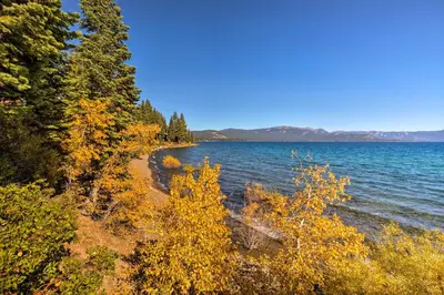 a shoreline of a lake with trees and water at 11 Mi to Palisades Tahoe Lakefront Home with View! in Tahoe City