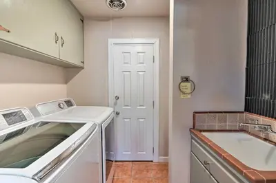 a small kitchen with a sink and a washing machine at Spacious Wine Country Home 1 Mi to Downtown Lodi! in Lodi