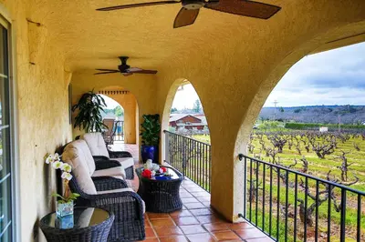 a porch with couches and a view of a vineyard at Working Vineyard and Private Pool Villa in Plymouth in Plymouth