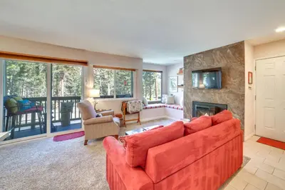 a living room with a red couch and a fireplace at Quiet Condo with Great Views, half Mi to Eagle Lodge! in Mammoth Lakes