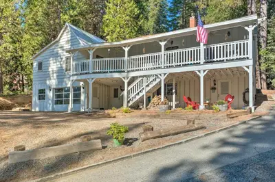 a house with a wrap around porch and an american flag at Strawberry Hill Cabin 5 Mi to Skiing and Lake in Strawberry