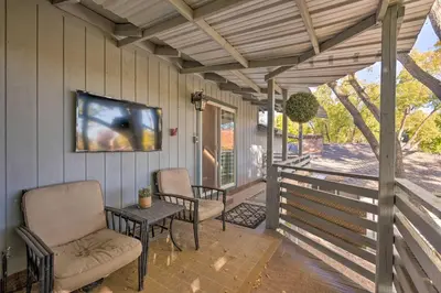 a porch with chairs and a tv on the wall at Luxurious Downtown Lodi Apartment in Wine Country! in Lodi