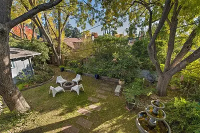 a backyard with two white chairs and a tree at Luxurious Downtown Lodi Apartment in Wine Country! in Lodi
