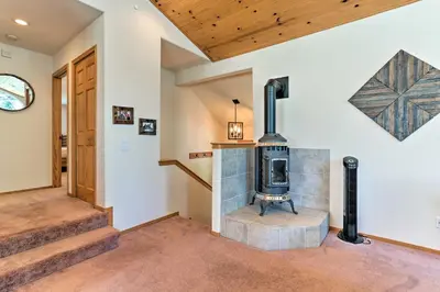 a wood stove in a living room with stairs at Forest Views and Beach Access Family Truckee Gem in Truckee