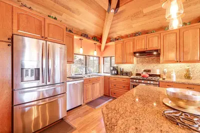 a kitchen with wooden cabinets and a stainless steel refrigerator at 1 Mi to Lake Tahoe Home with Hot Tub and Decks in Tahoe City