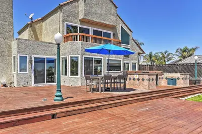 a house with a deck with a table and an umbrella at Waterfront Discovery Bay Home Outdoor Bar and Dock in Discovery Bay