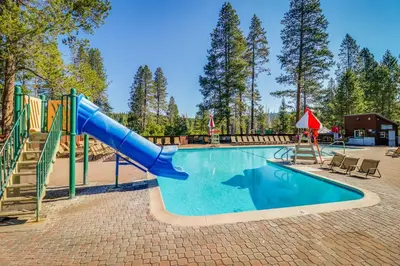 a swimming pool with a slide and a playground at Charming Mountain Chalet in Truckee