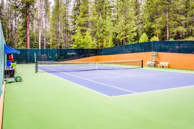 a tennis court with two chairs and a net at Spike's Place in Truckee
