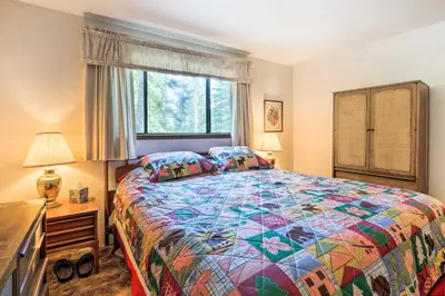 a bedroom with a colorful bed and a window at Near Hiking and Skiing Bear Valley Cabin! in Tamarack