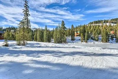 a snow covered field with trees and a house at Near Hiking and Skiing Bear Valley Cabin! in Tamarack